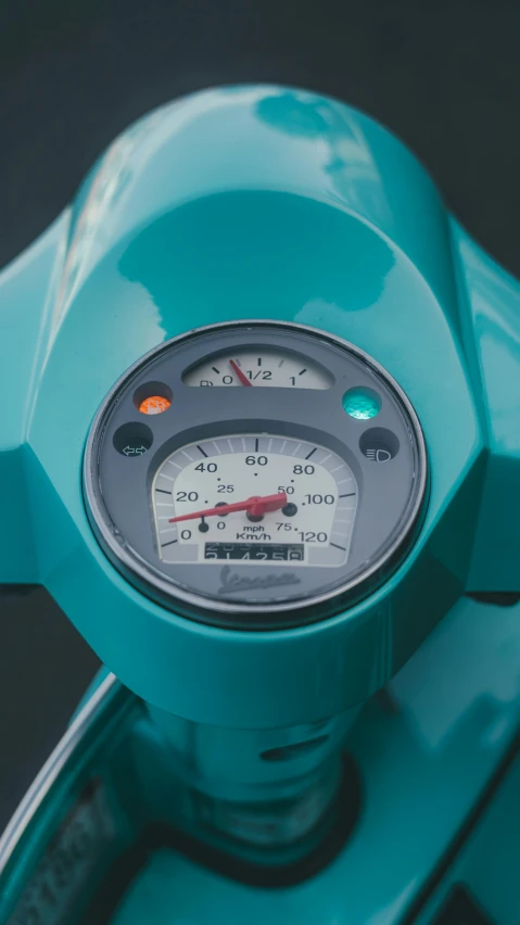 a view of a light blue motorcycle dashboard