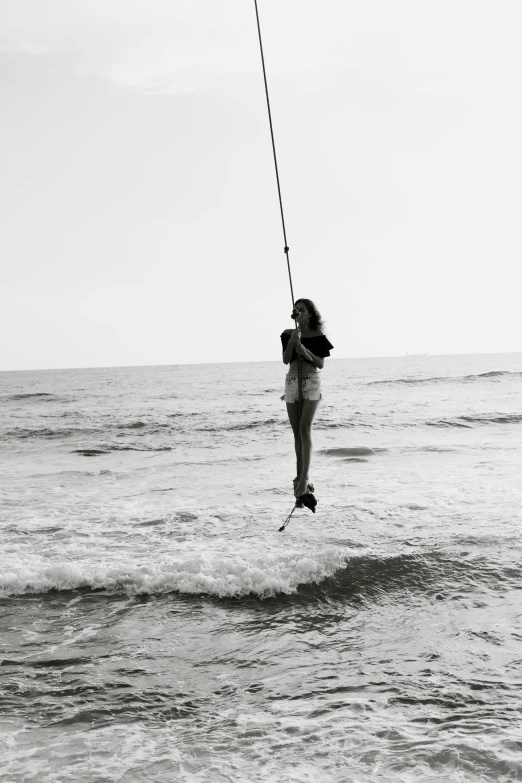 black and white pograph of a woman being pulled on a surfboard by someone