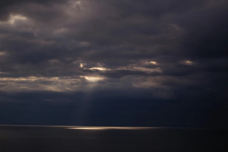 a boat on the water is under some dark clouds