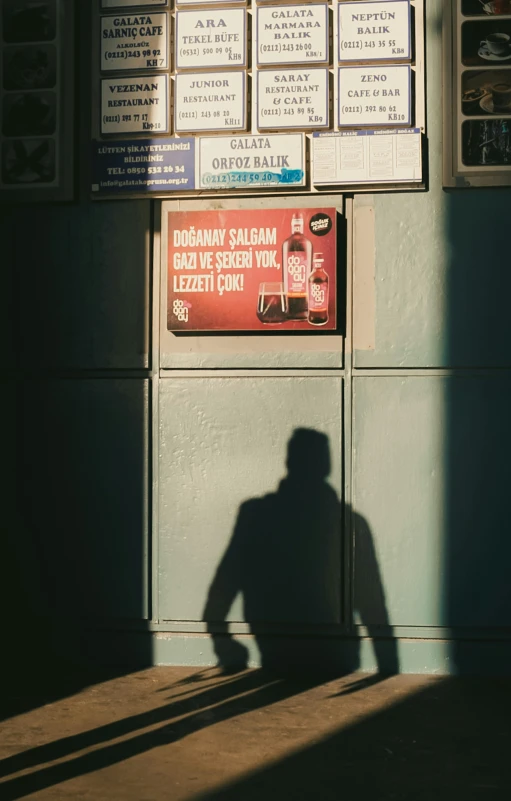 two people are standing in the shadow of a sign