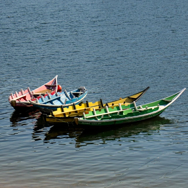 three colorful boats in the water with blue sky