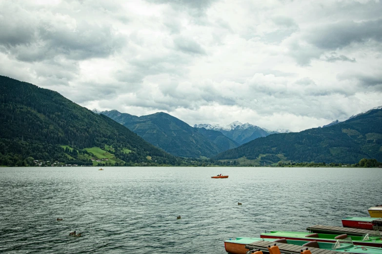 boats sit in the water in front of mountains