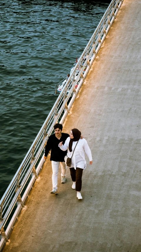 two people walking by a dock towards water