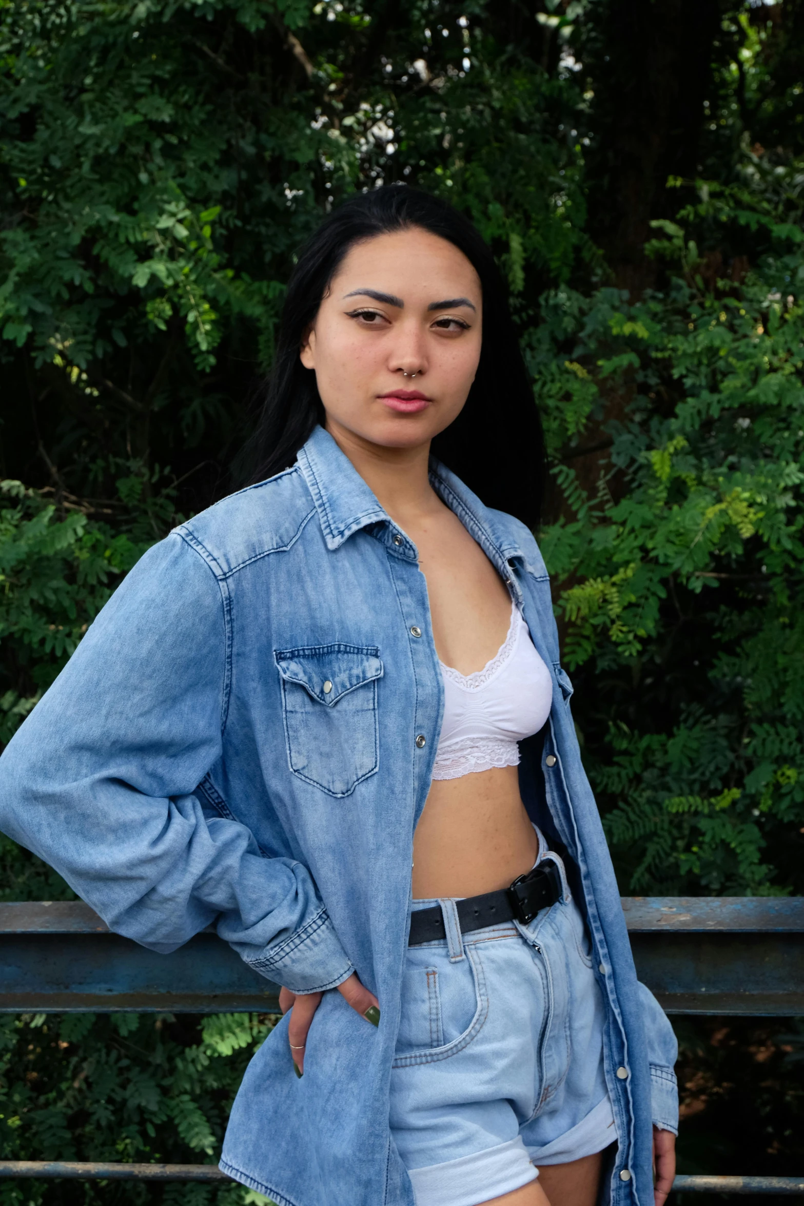 a woman wearing denim shorts, a white shirt and a jean jacket