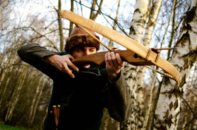 a man in the woods holding a large piece of wood