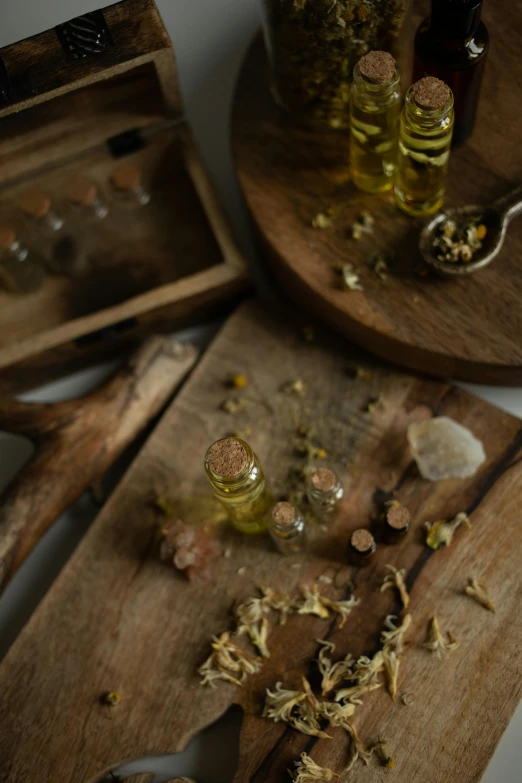 several bottles of oil and flower petals and some olives on the table