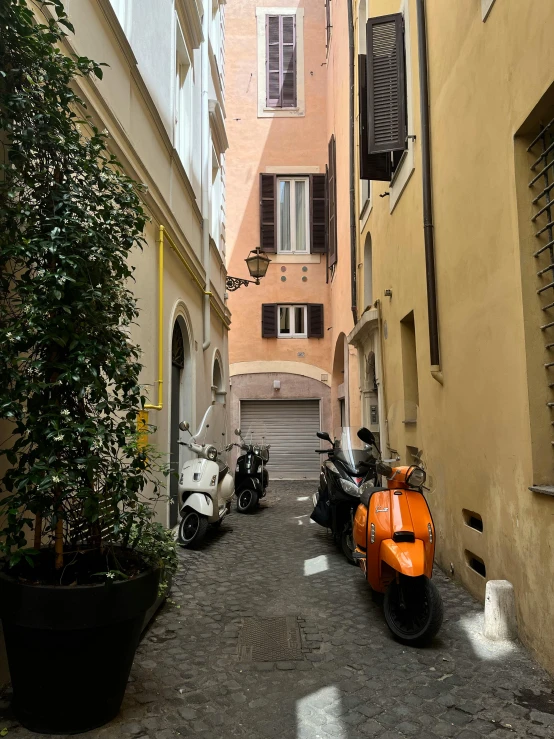 two motor bikes parked in between buildings on a narrow street