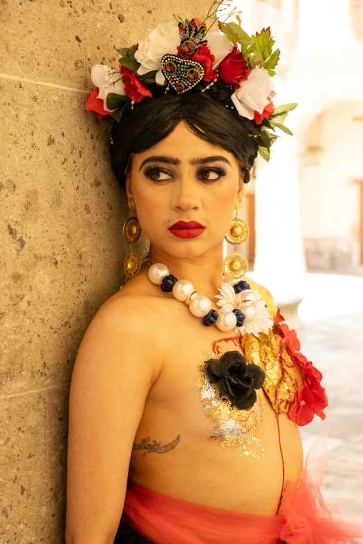 a woman with tattoos wearing a flower crown and headdress