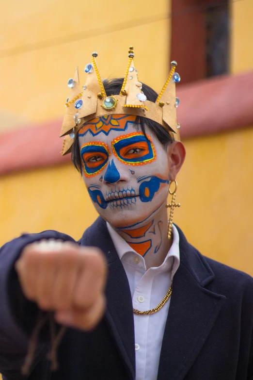 a man wearing a gold crown painted on his face