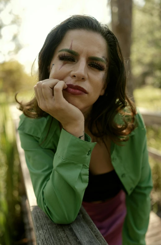 a woman sitting on a bench in a green shirt