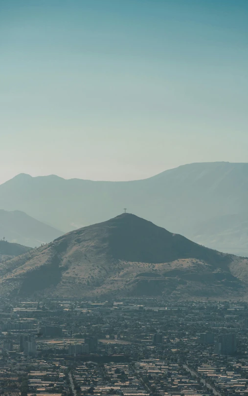 a large mountain range with a few buildings below