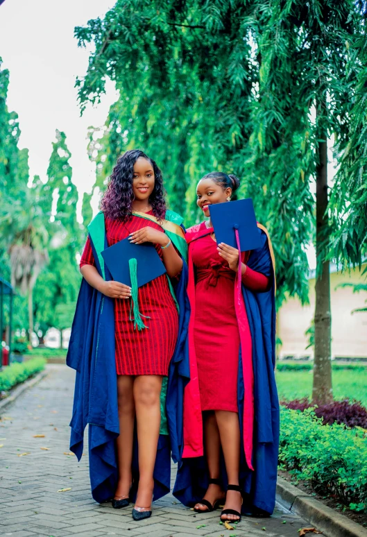 three women standing next to each other with a backpack on and graduation hats on