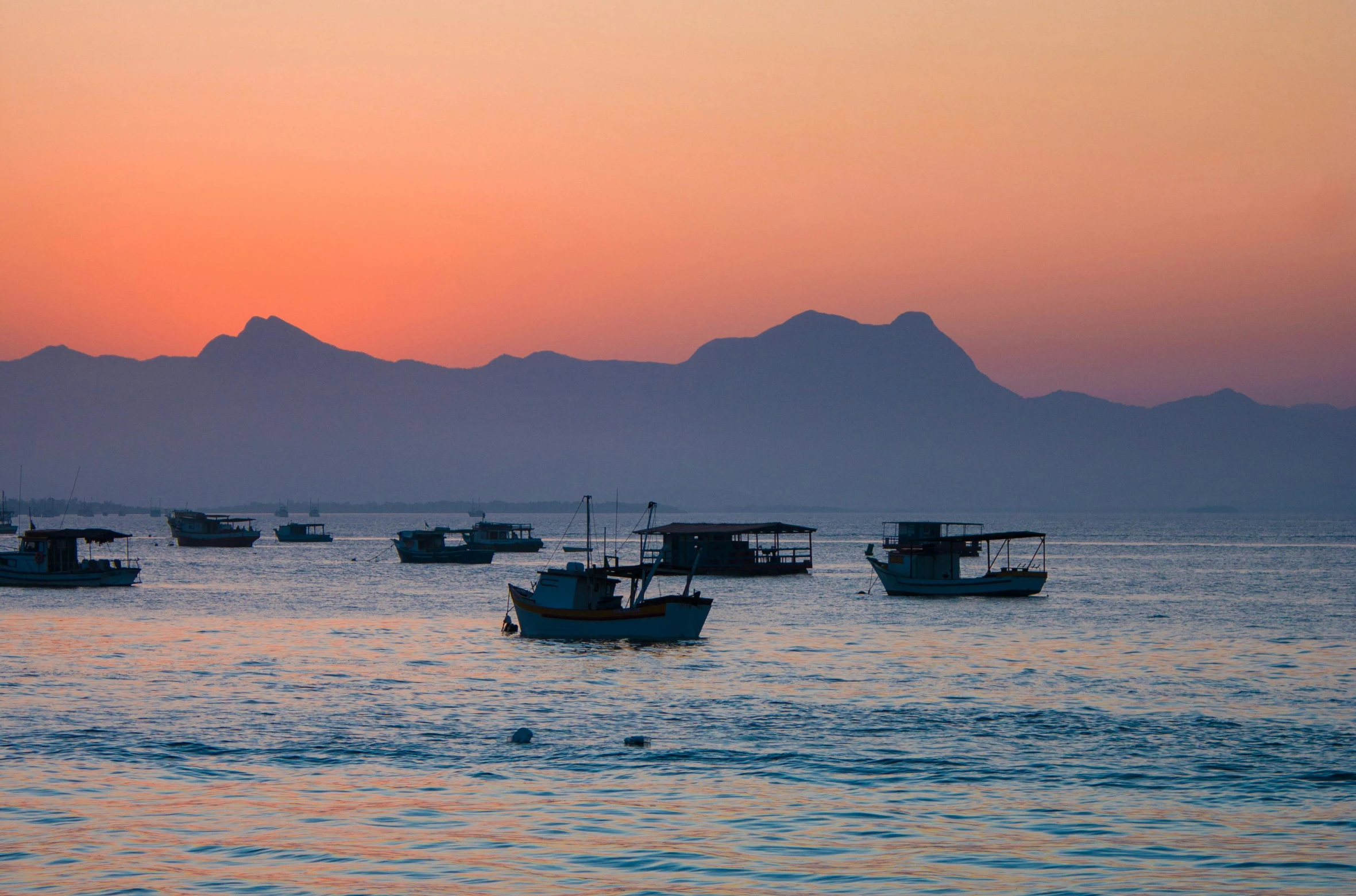 many boats are out on the water at sunset