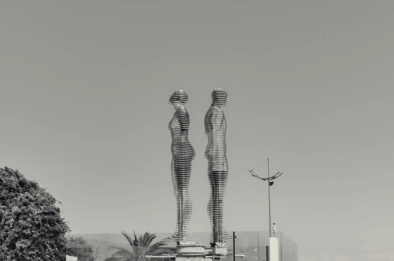 black and white pograph of a couple of statues next to a building