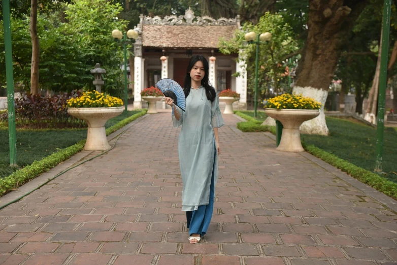 a woman walking across a walkway holding an umbrella