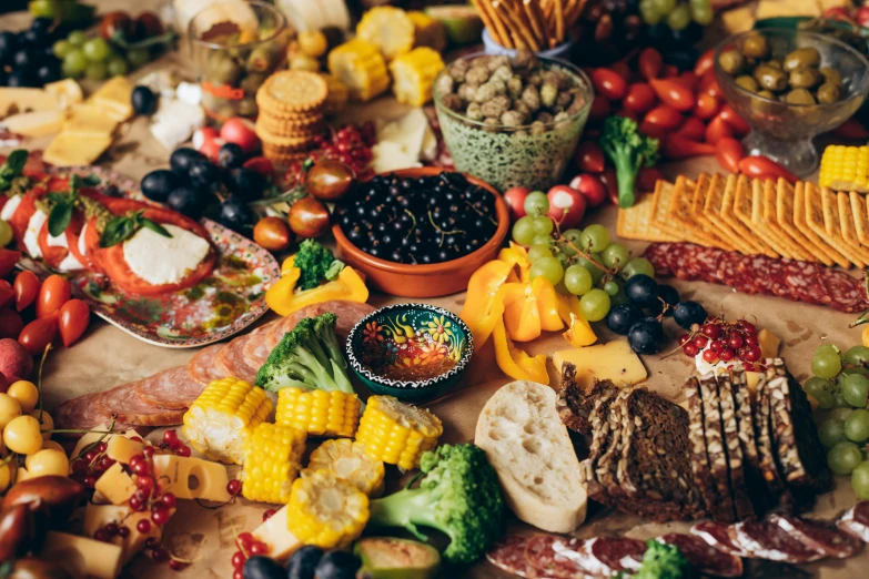 some gs, gs, oranges and corn sit on a table with fruits