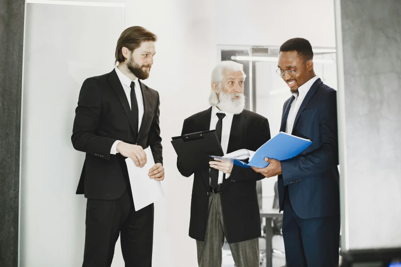 three well dressed men are meeting at an office