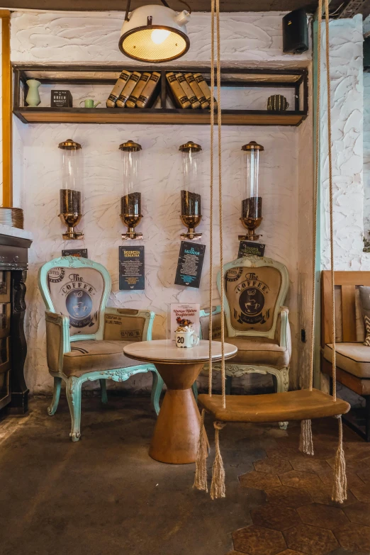 the interior of a restaurant with two swings that look like chairs