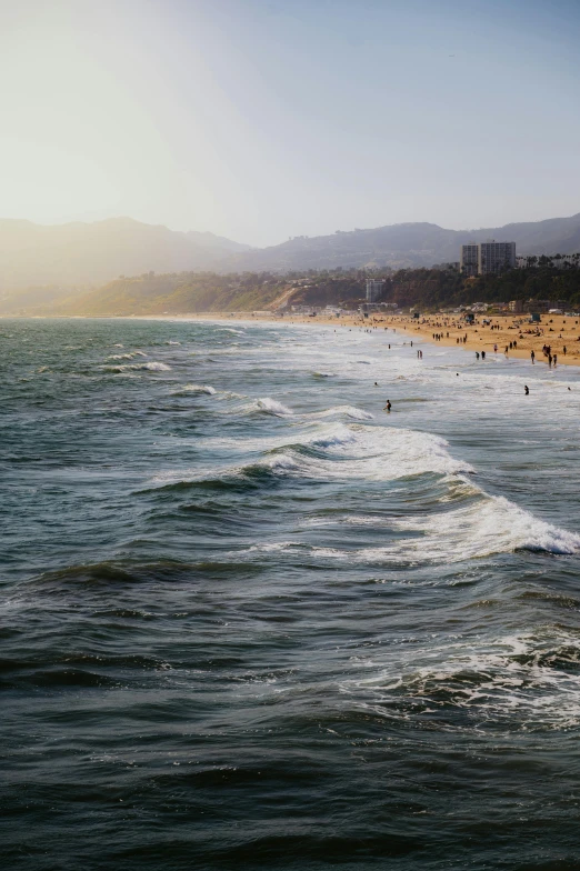 people walking on the beach while waves roll in