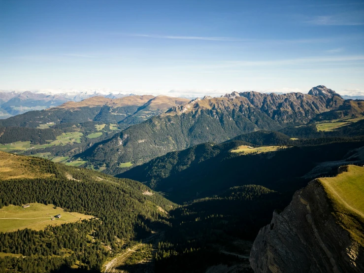 the top of a mountain range with a grassy valley below