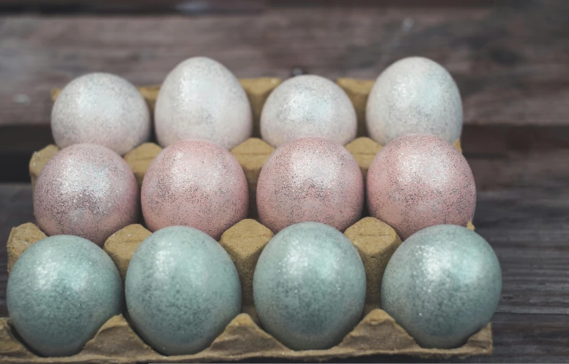 a box full of dyed eggs with speckled surfaces