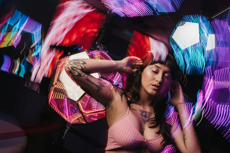 a woman wearing a pink  is surrounded by colorfully colored wings