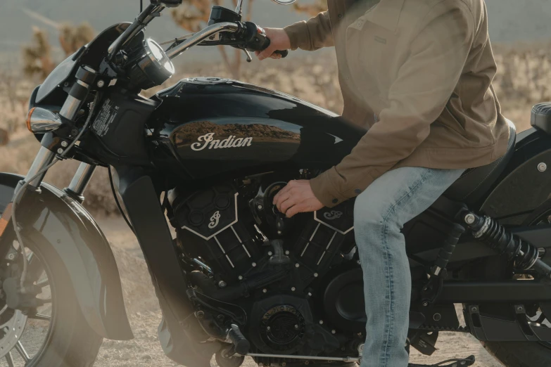 a person on a black and brown motorcycle with some desert