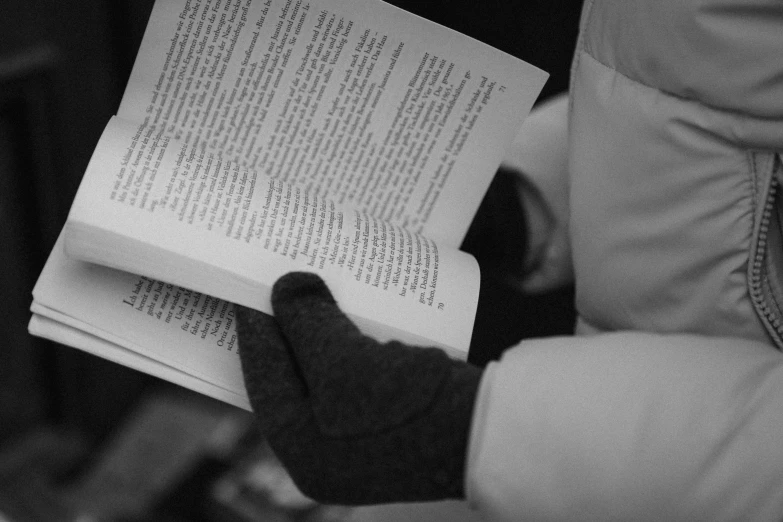 a woman in a coat reading a book