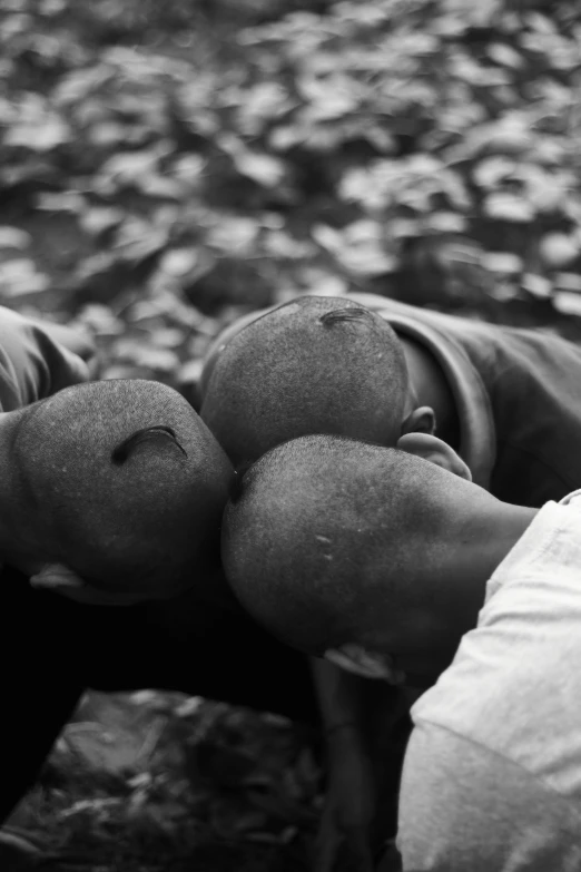 two people who are bending over and holding apples