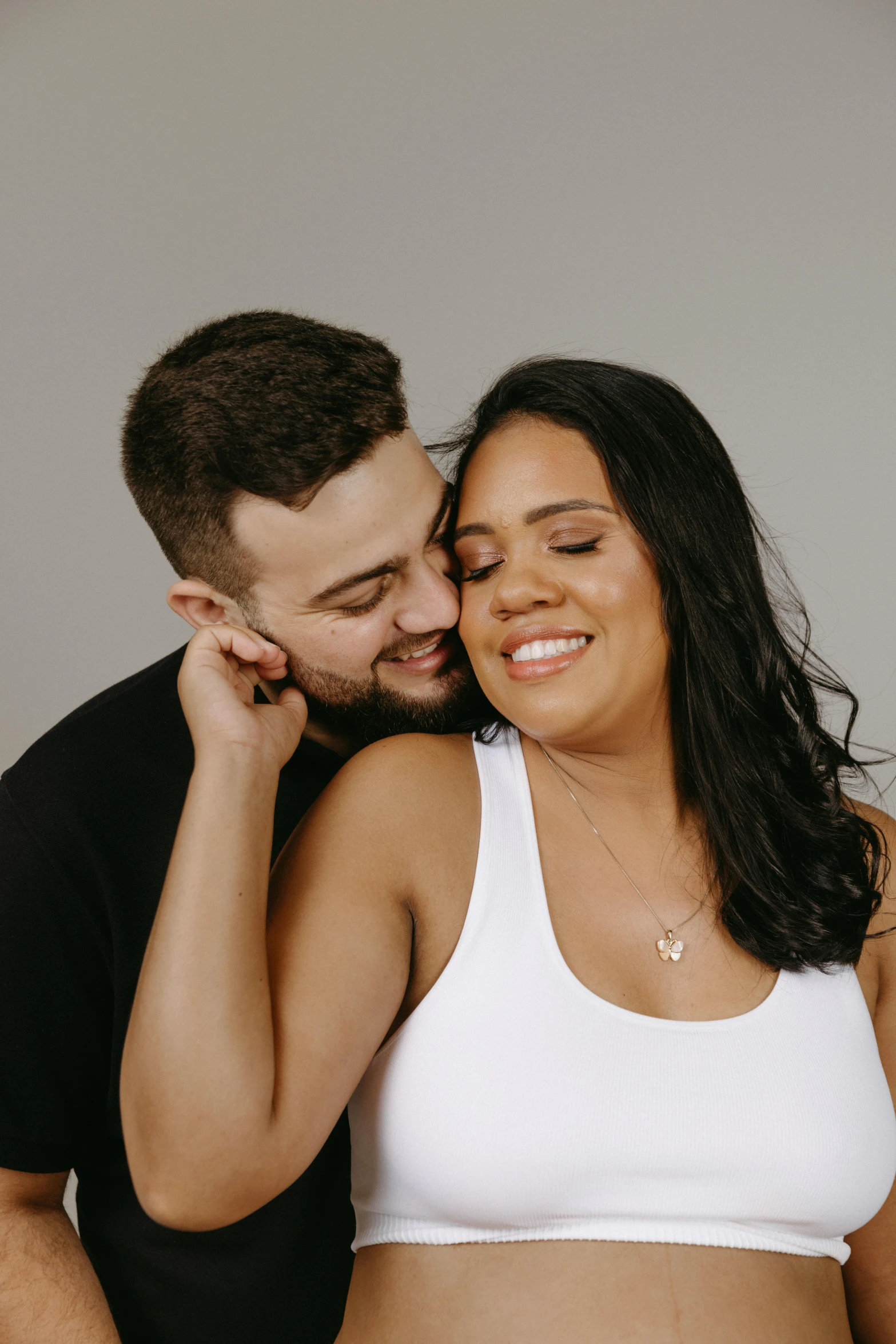 a woman and man smiling while emcing each other