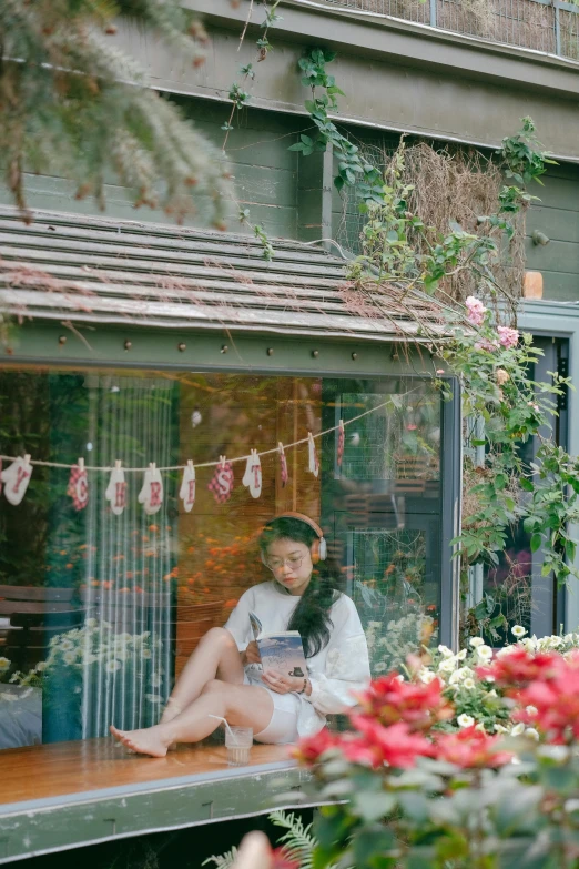 a woman in white dress sitting on window ledge