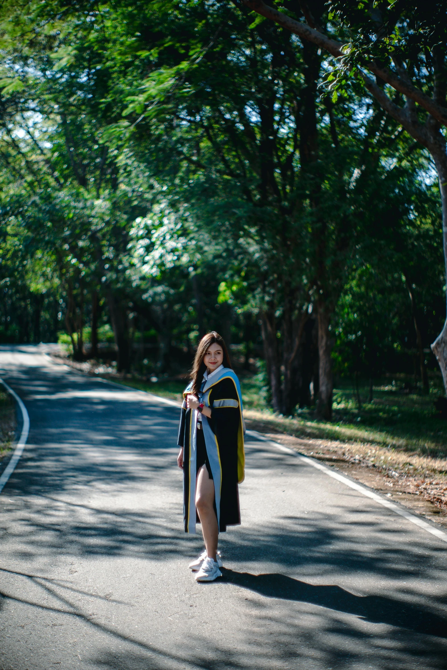 the woman is standing on the road holding onto an umbrella