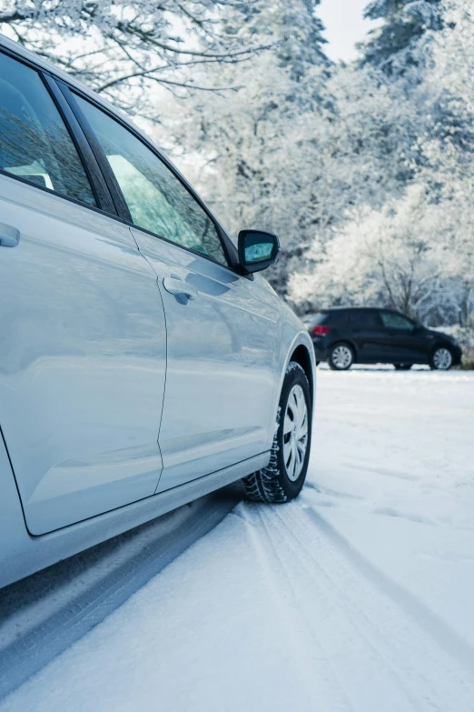 cars traveling on snow in winter near trees