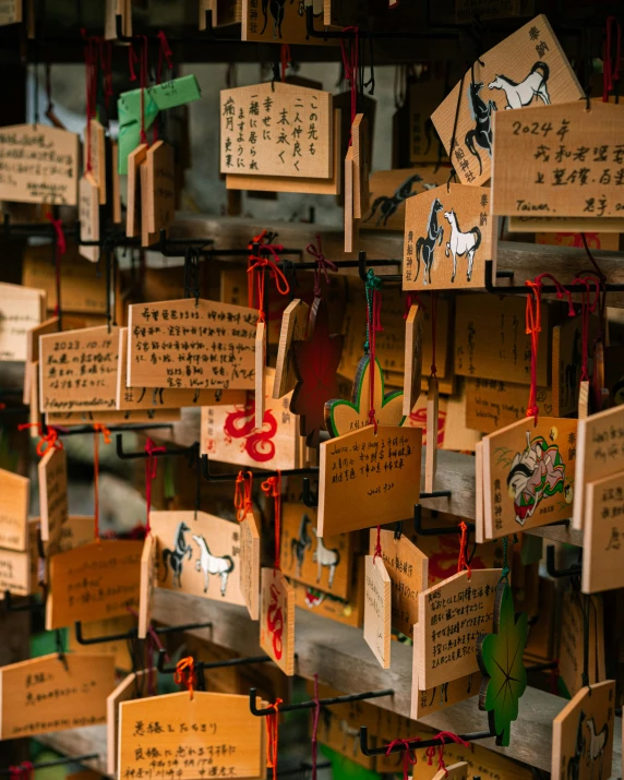 lots of chinese style paper and cards hanging on a wall