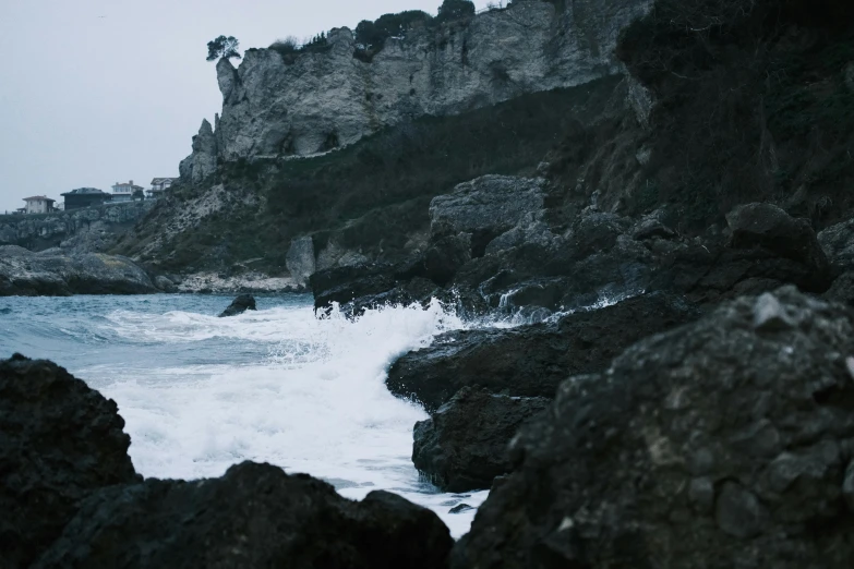 waves are coming in on the shore by a small rock