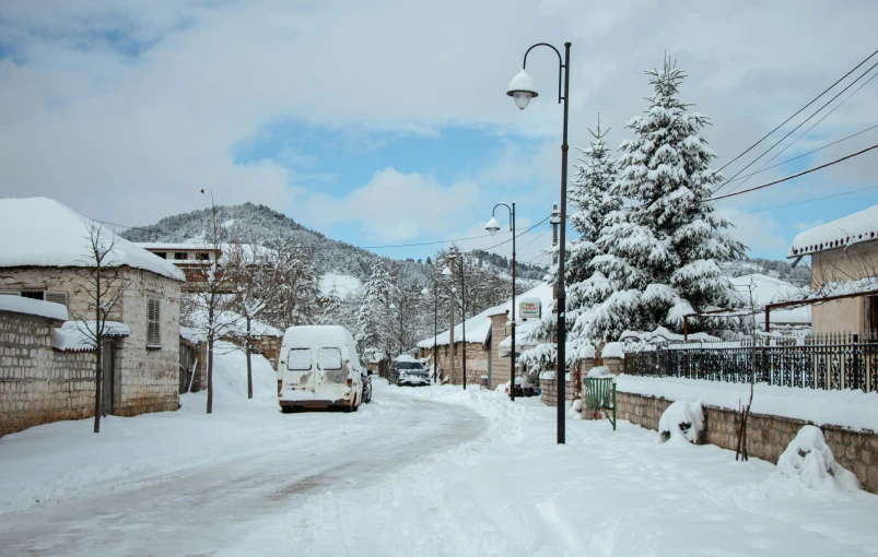 the car is traveling down the snowy street