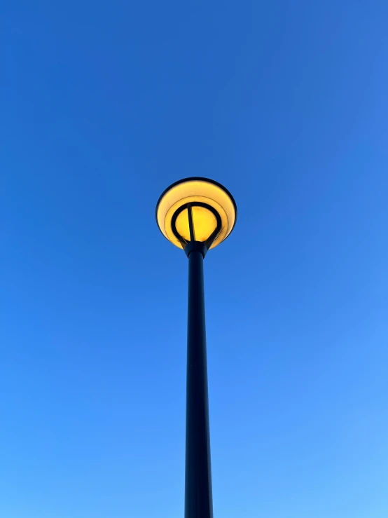 a yellow light that is on some kind of pole