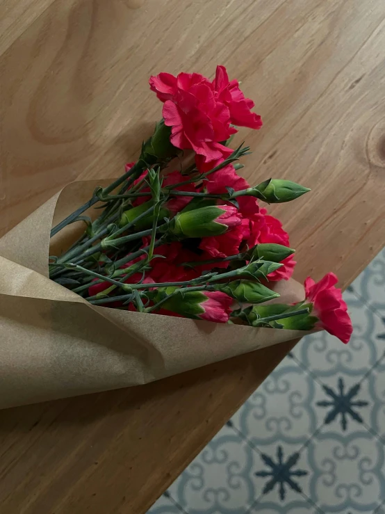 flowers are in a brown paper bag on a table