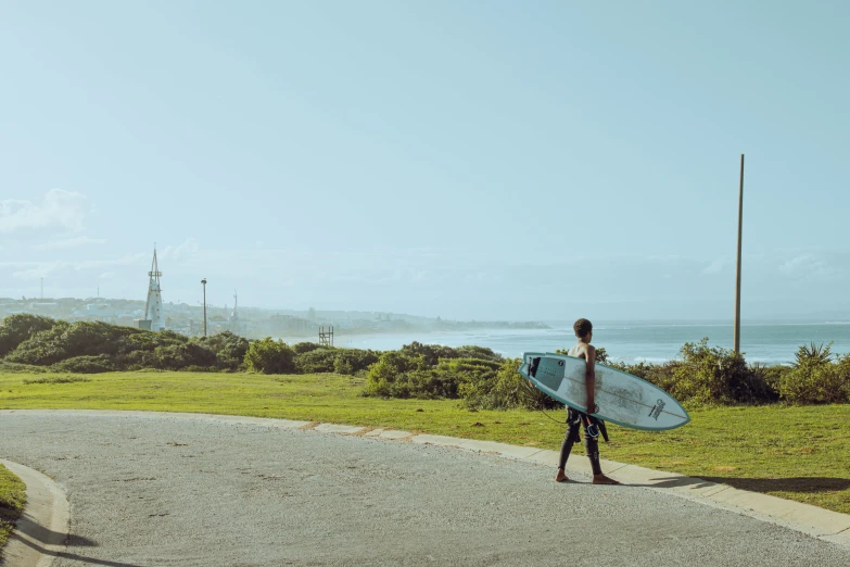 man walking toward the ocean with a surfboard