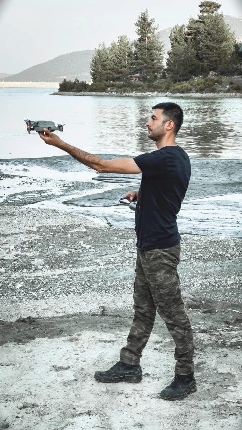 a man with his arms out while shooting a revolver