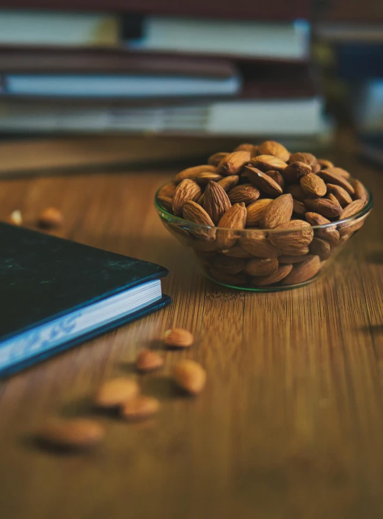 a bowl of almonds on a wooden table