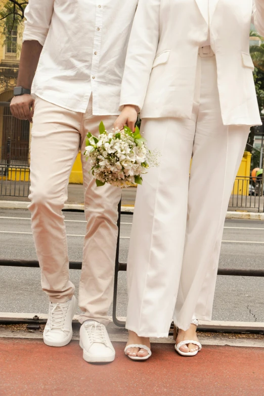 the couple is posing in white outfits