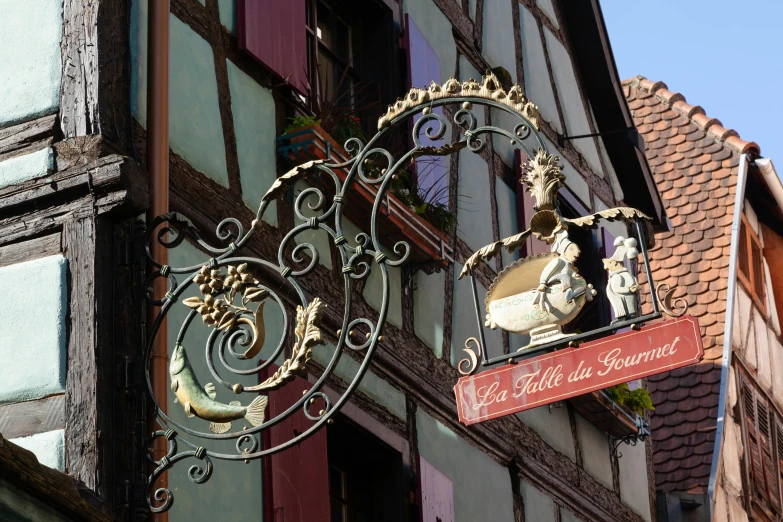 ornate decorative iron and glass work on building with sign