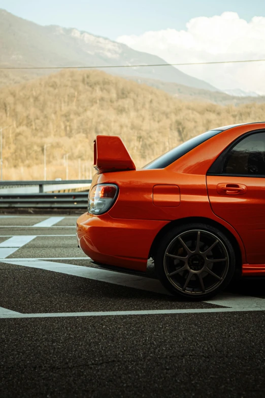 an orange car that is parked in a lot