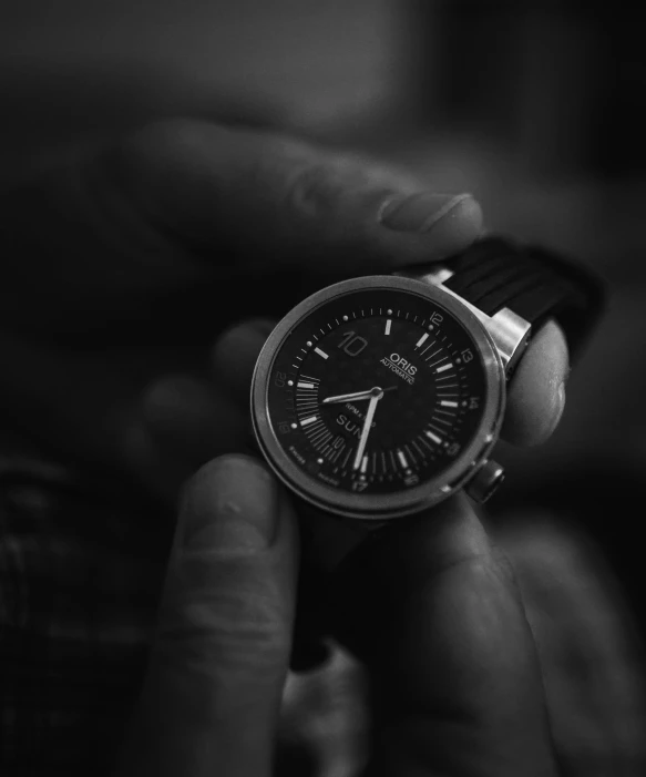 man holding watch, black and white pograph