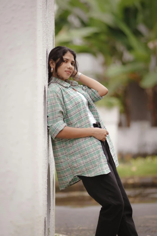 a girl leans against a wall while leaning on her head