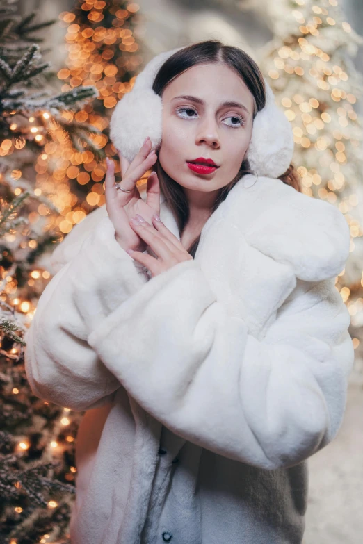 a  poses in front of a christmas tree