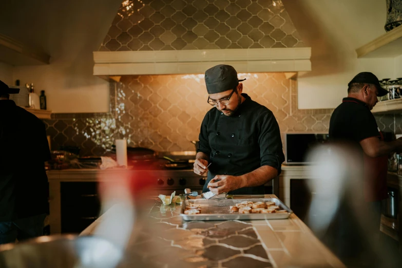 a man standing at the counter in a kitchen preparing food