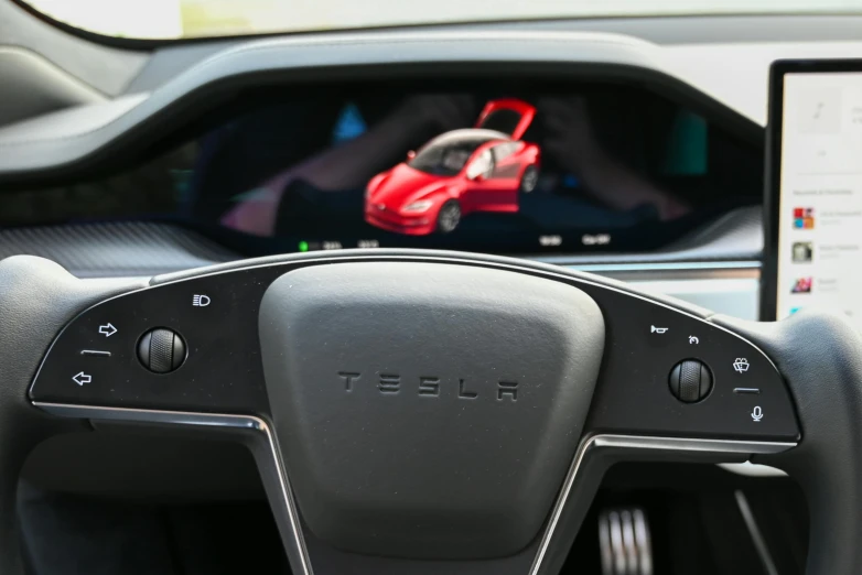 a red toy car is shown behind the steering wheel