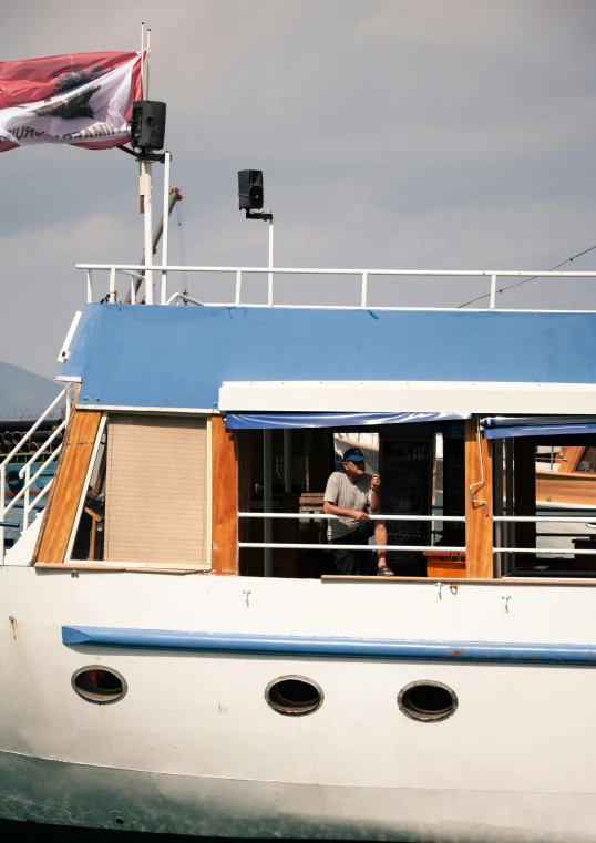 two people on a boat with flags flying overhead